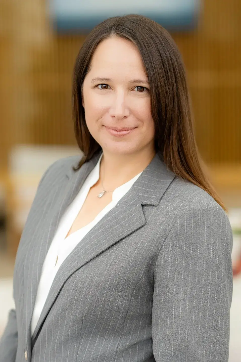 A woman in a gray suit standing next to a building.