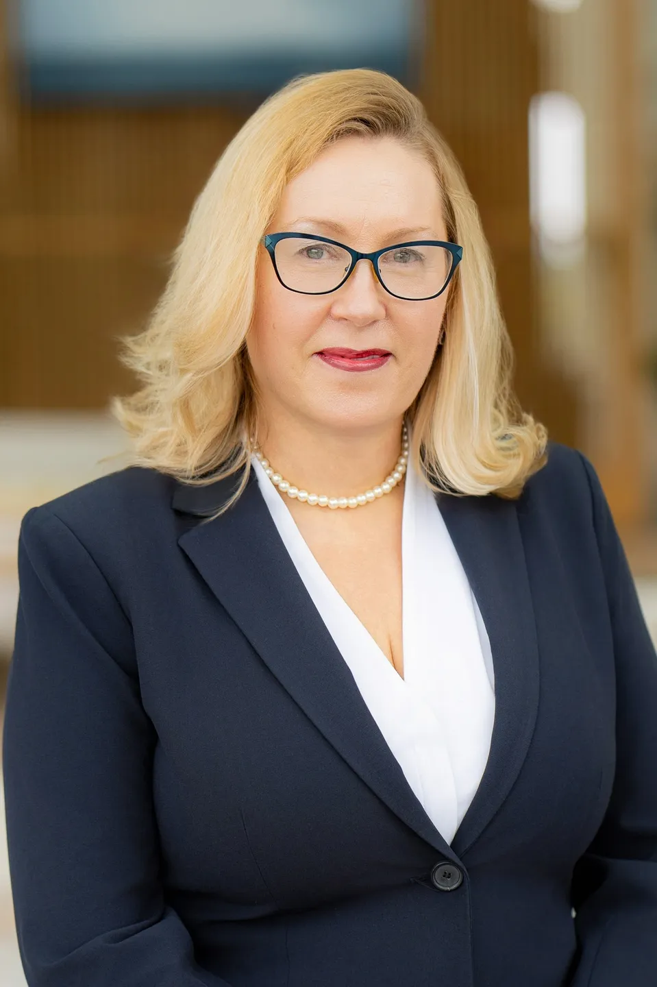 Blonde businesswoman in navy suit and pearls